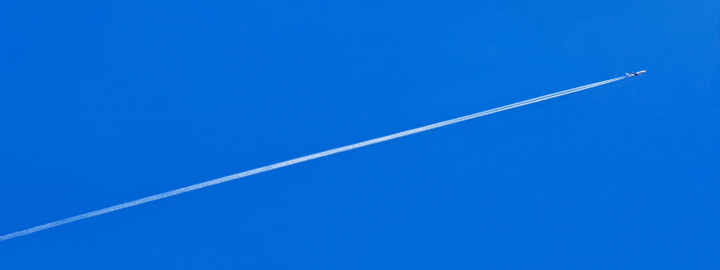 雲一つない青空を一直線に進む飛行機